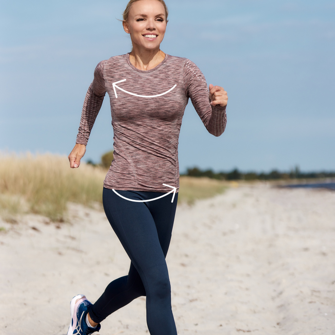Thora fra Superfit Mor demonstrerer rotation I kernevenlig løbeteknik på stranden. Løb for kvinder